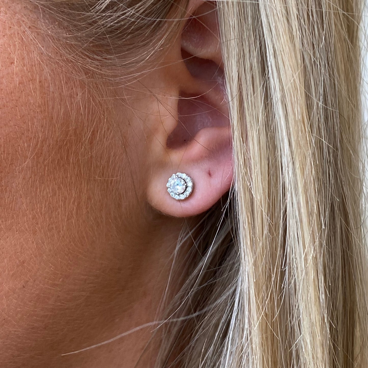 Silver round CZ halo stud earrings by Comero featuring sparkling cubic zirconia in a classic round design.