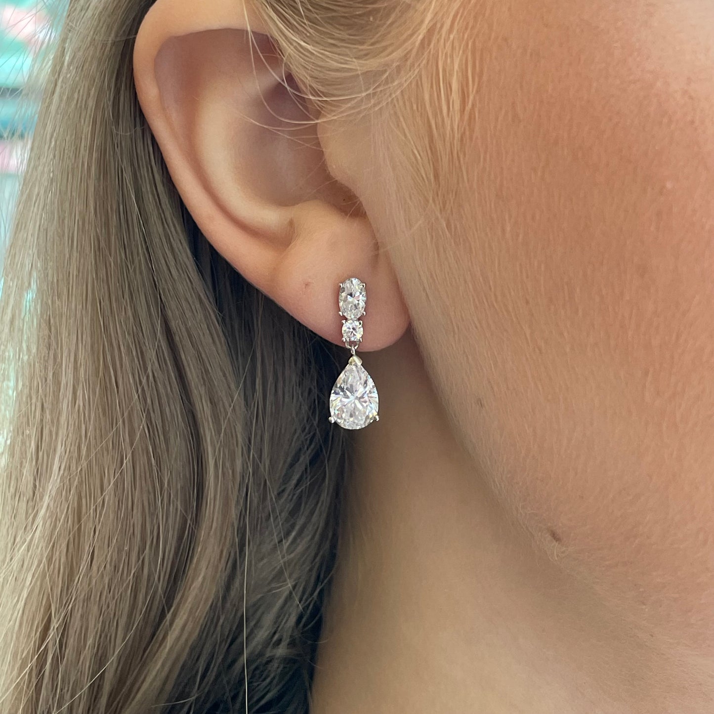 Silver C-Flawless Pear CZ Drop Earrings by Insignia featuring pear-shaped cubic zirconia stones and elegant dangle design.