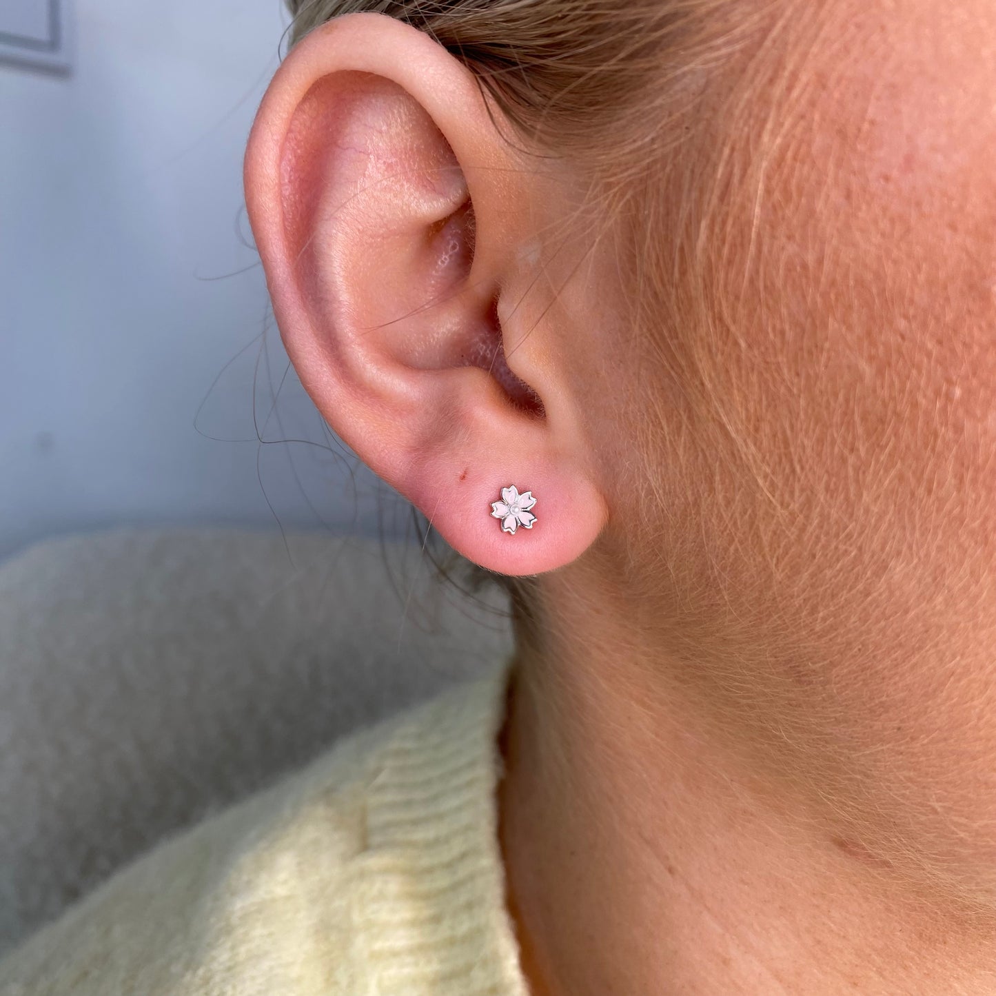 Silver white enamel flower kid's stud earrings by Comero featuring delicate floral design and silver metal finish.