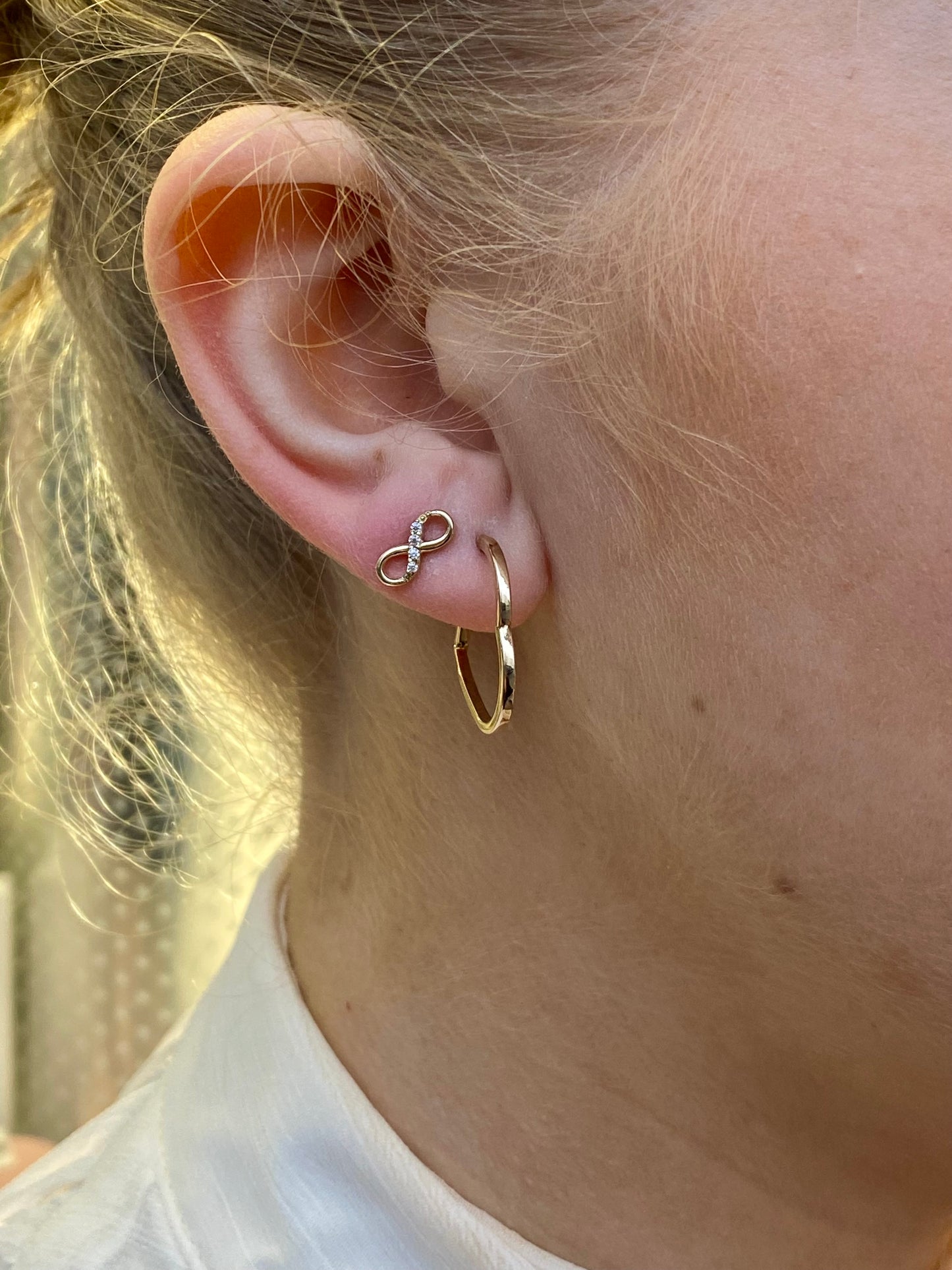 NJO 9ct gold CZ infinity stud earrings with sparkling cubic zirconia on a white background.