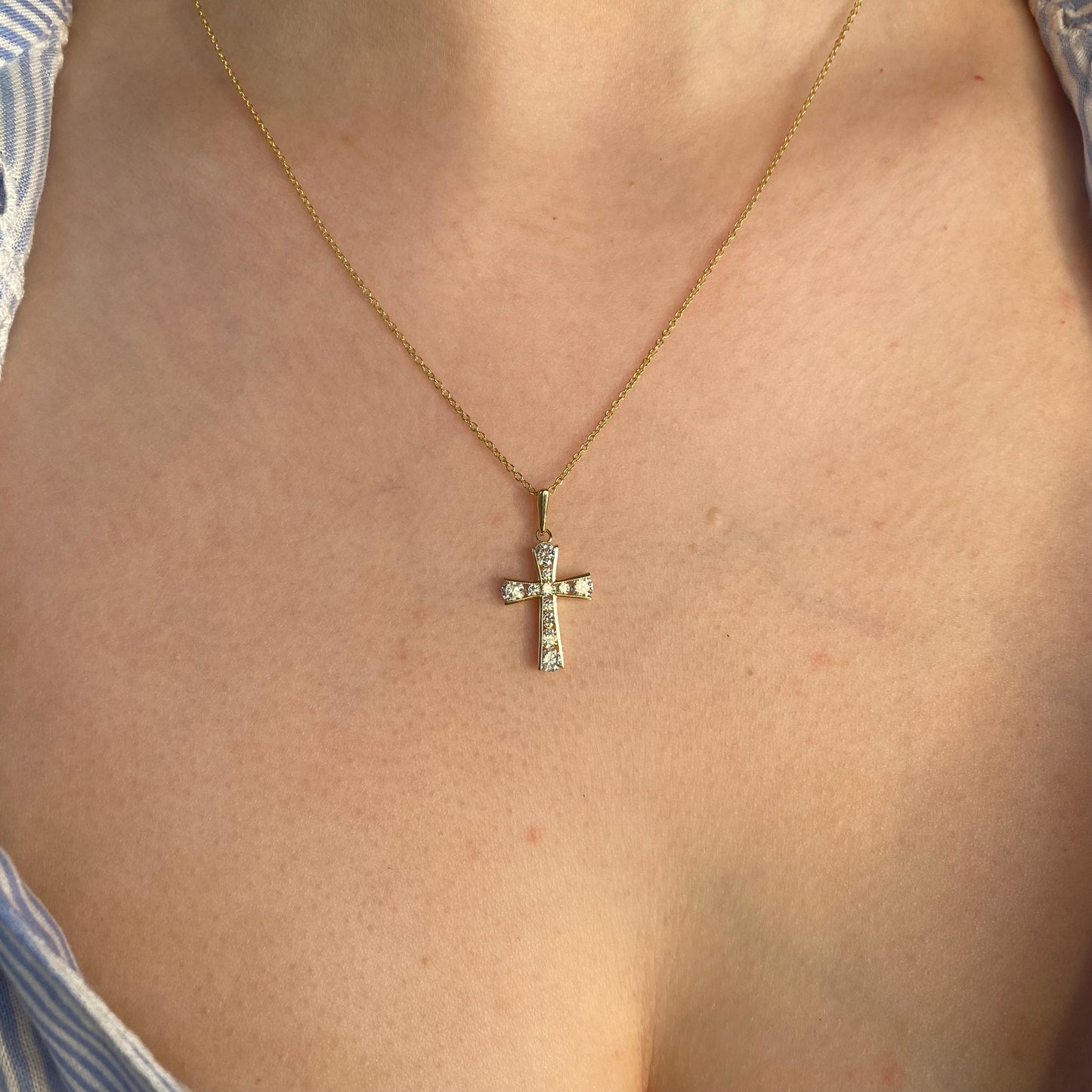 Small 9ct gold CZ cross pendant necklace from IDL, featuring a delicate design with sparkling cubic zirconia stones.