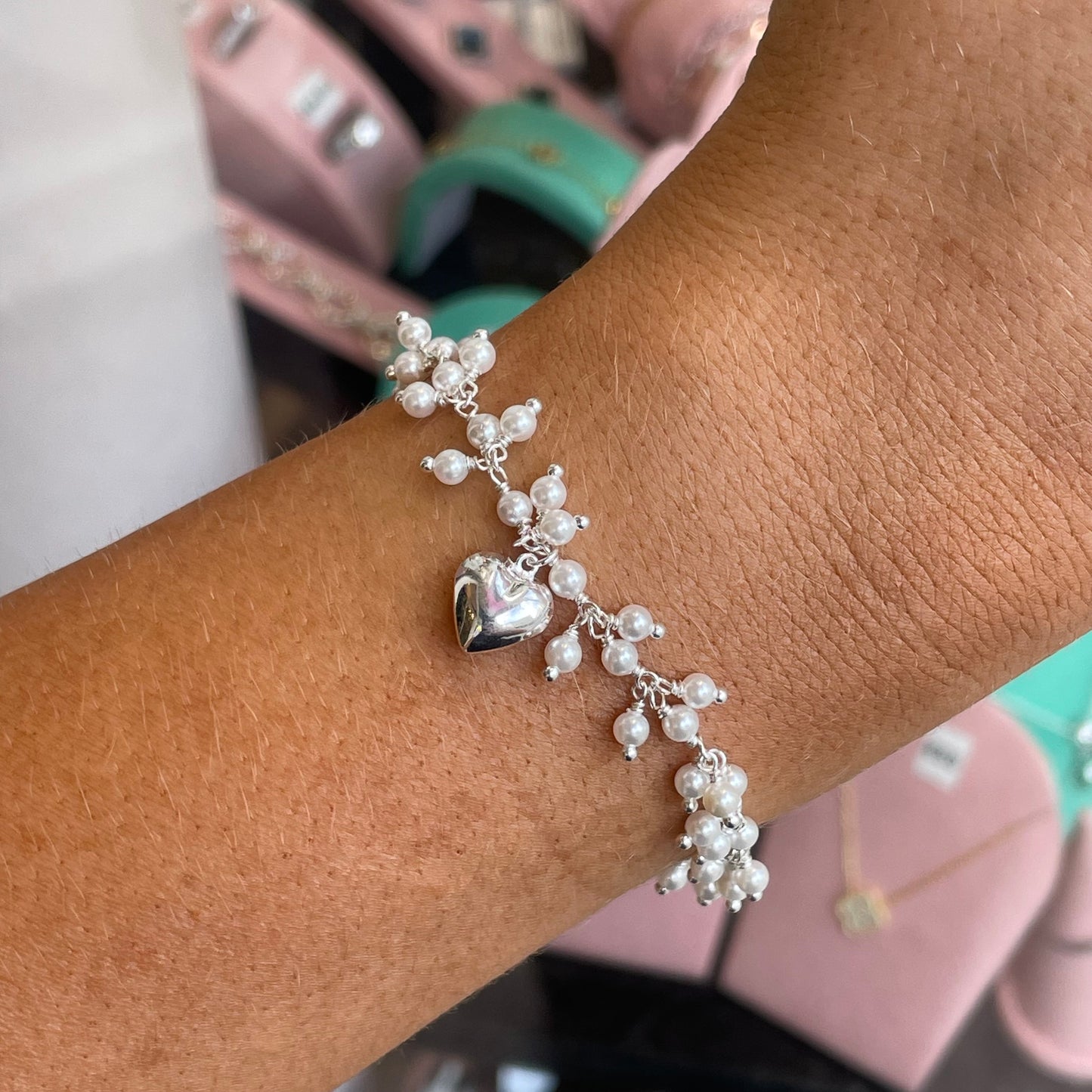 Silver faux pearl and heart charm bracelet by CME featuring elegant design and intricate detailing.