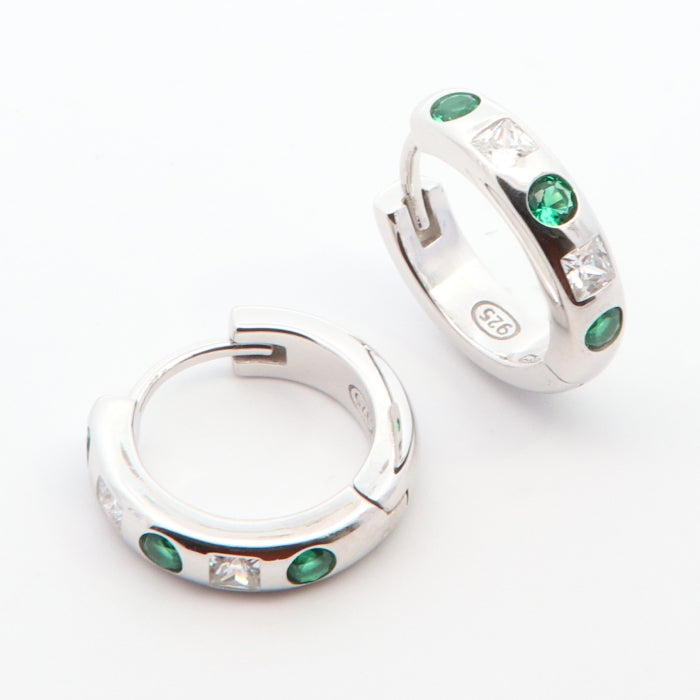 Silver green CZ hoop earrings by Comero featuring shiny hoops with vibrant green cubic zirconia accents.