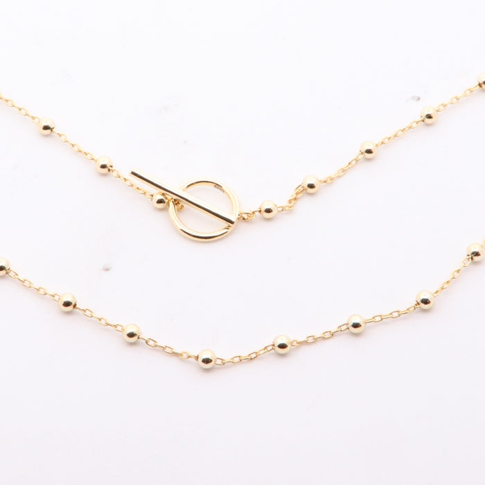 Sunshine beaded T-Bar necklace by Comero featuring colorful beads and a sleek T-shaped pendant on a silver chain.