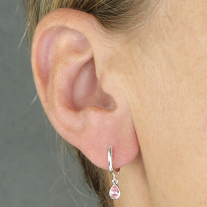 Silver pink CZ horseshoe huggie hoop earrings by CME, featuring sparkling stones and a sleek hoop design.
