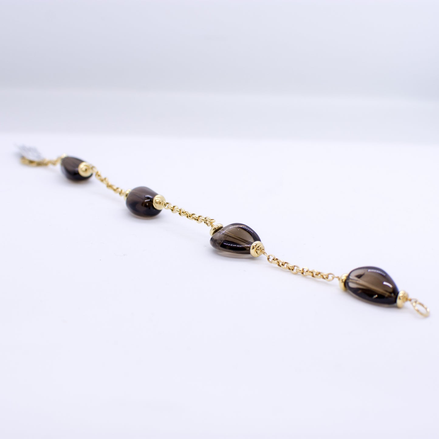 18ct Gold Smoky Quartz and Chain Bracelet Smoky Quartz dimensions: 10mm x 12mm approximately Diamond cut 2mm gauge solid trace chain 19cm long 18ct yellow gold This item can be ordered in a variety of lengths. Please contact us for custom requirements.
