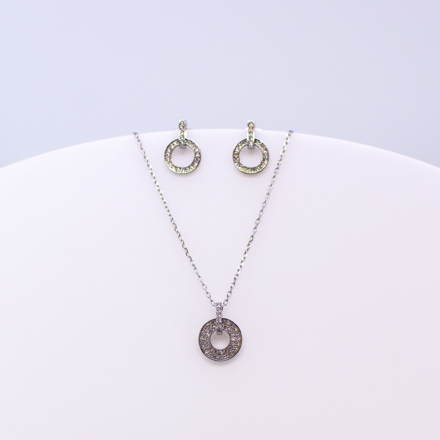 These sterling silver drop open circle stud earrings set with glittering cubic zirconia stones accompanied by the matching necklace are the perfect addition to any outfit. Product details: Product materials: 925 sterling silver, cubic zirconia Pendant dimensions: 13.5mm L x 10mm W Chain length: 44cm inch fine diamond cut curb chain Earring dimensions: 13mm L x 8.5mm W Stud earrings with butterfly backs.