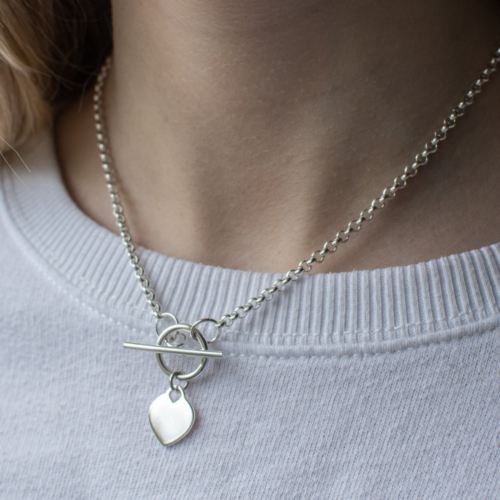Silver Heart Disc T-Bar Necklace by Kurate, showcasing a delicate chain with a heart-shaped disc pendant and T-bar clasp.