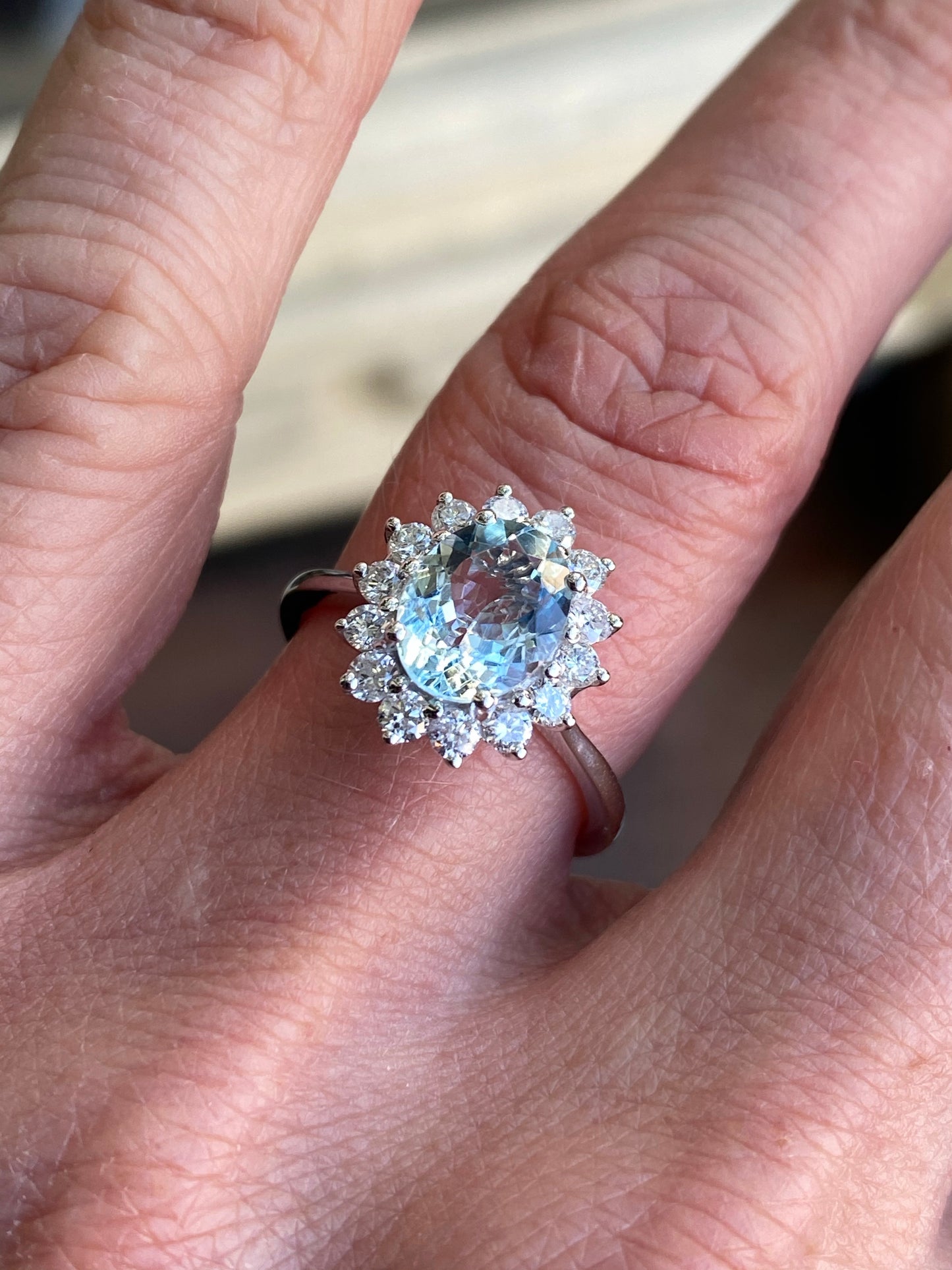 18ct white gold aquamarine and diamond ring with a central oval aquamarine gemstone and surrounding sparkling diamonds.