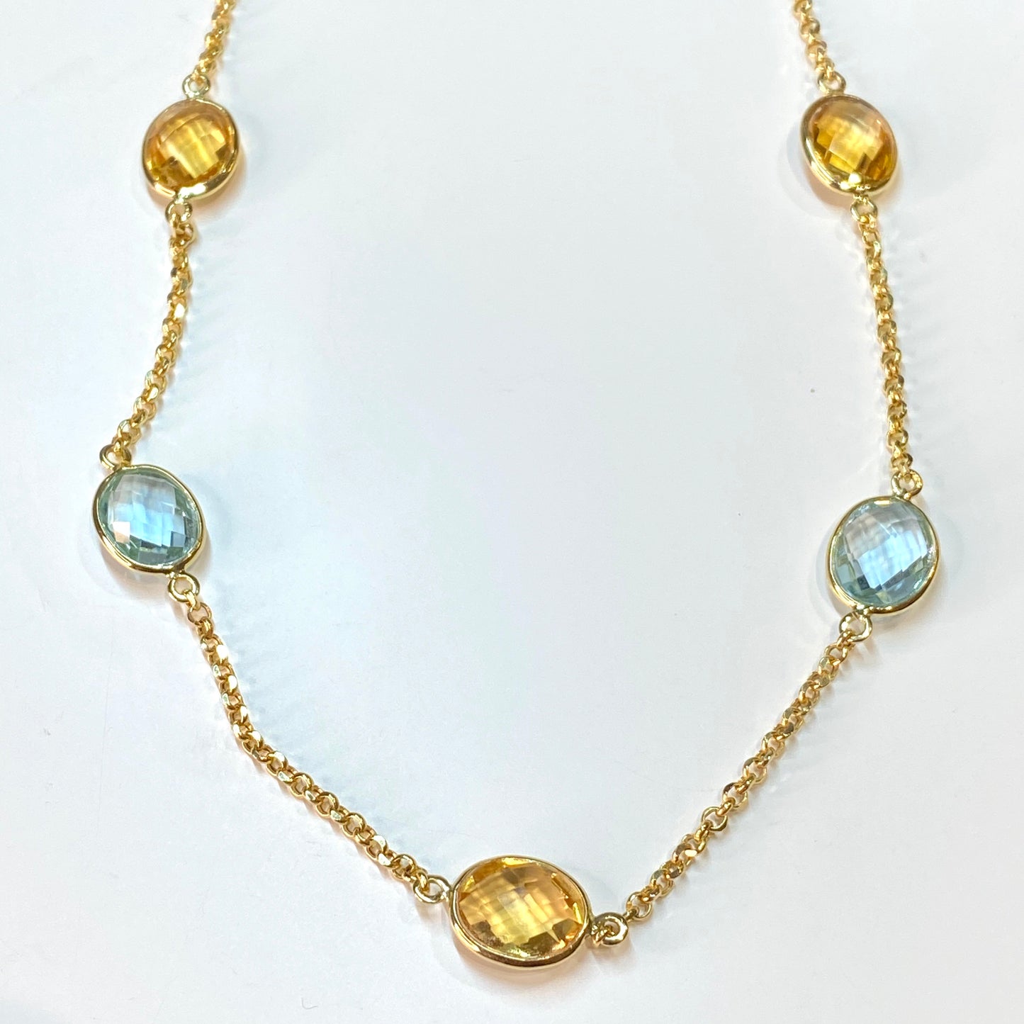 18ct gold light blue topaz and citrine chain necklace by Mattia, featuring a delicate gold chain with blue topaz and citrine gemstones.