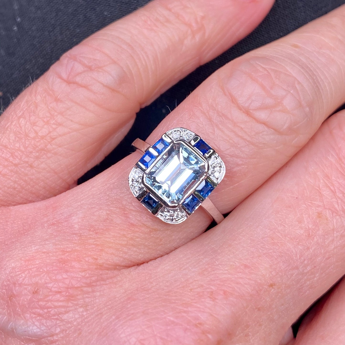 18ct white gold aquamarine, sapphire, and diamond ring with intricate design, featuring sparkling gemstones and fine craftsmanship.