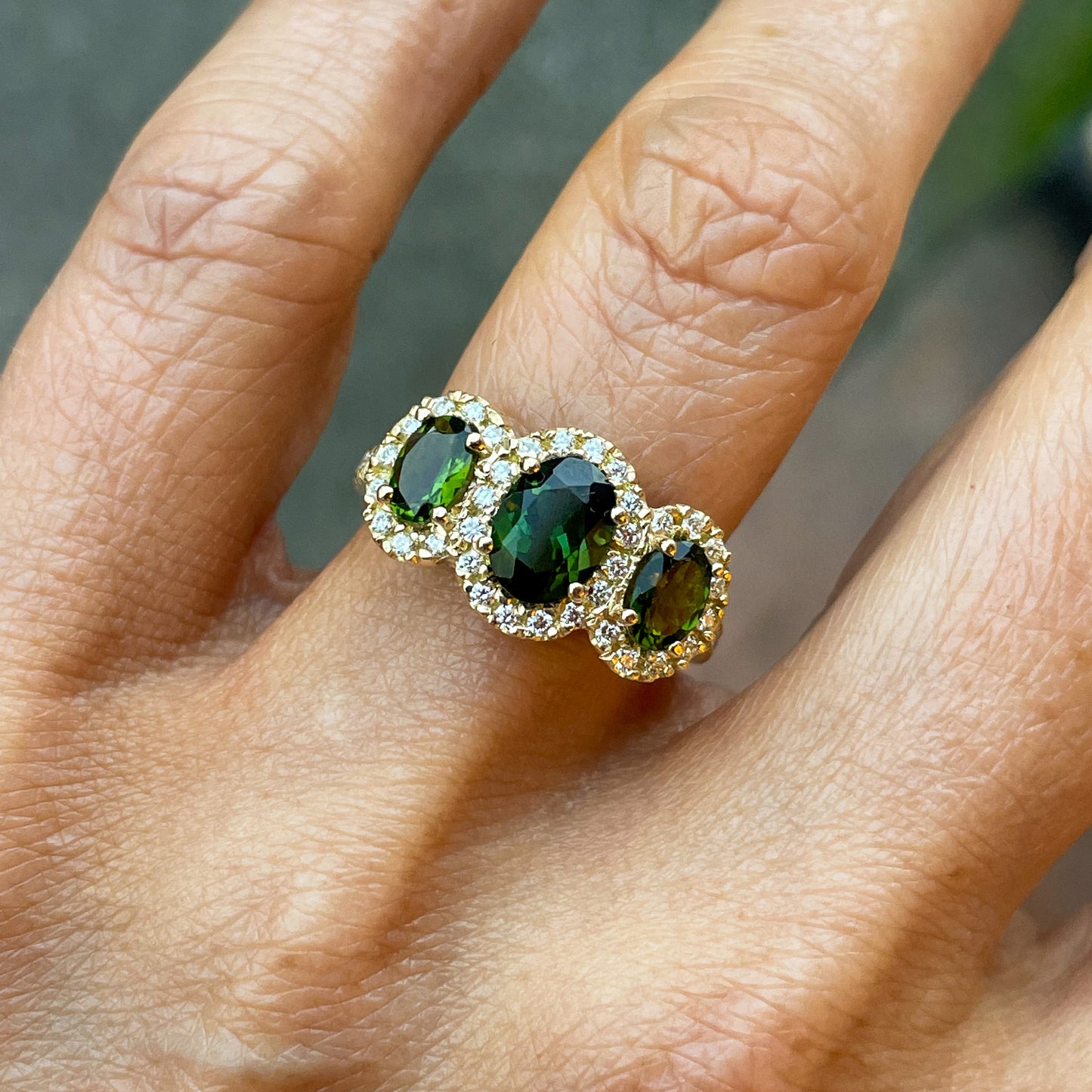 18ct gold green tourmaline and diamond garland ring by John Michael, with intricate gemstone and diamond details.