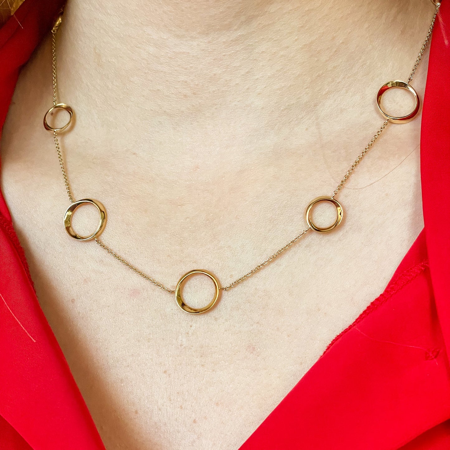 Marchetti Edoardo 9ct gold circles necklace with interconnected circular pendant design, close-up of the elegant jewelry piece.