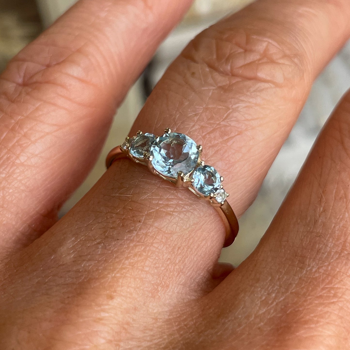 Insignia 9ct gold five-stone ring featuring sky blue topaz gemstones set in a polished gold band.