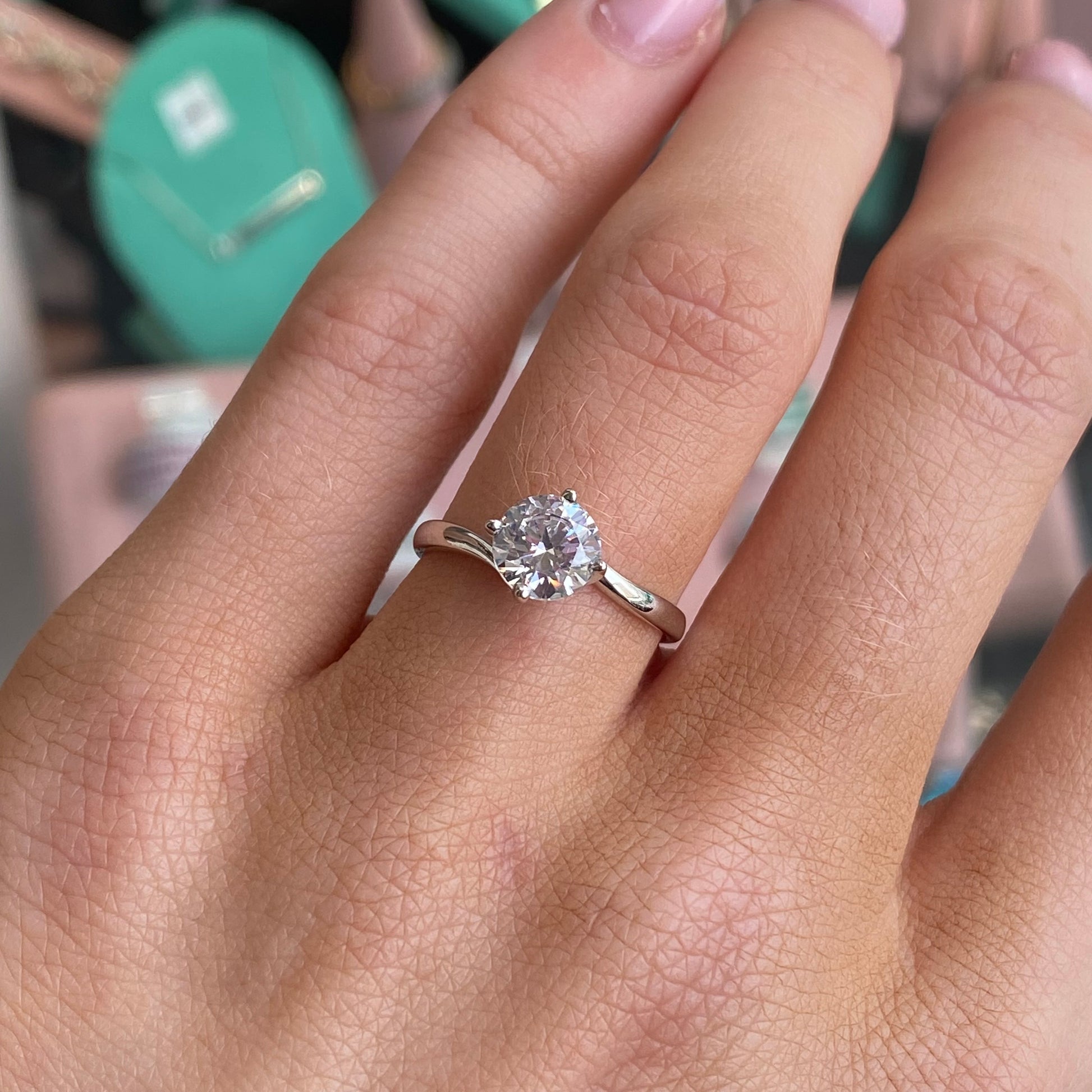 Silver elegant CZ twist promise ring by CME, featuring a sparkling cubic zirconia centerpiece and a sleek twisted band design.