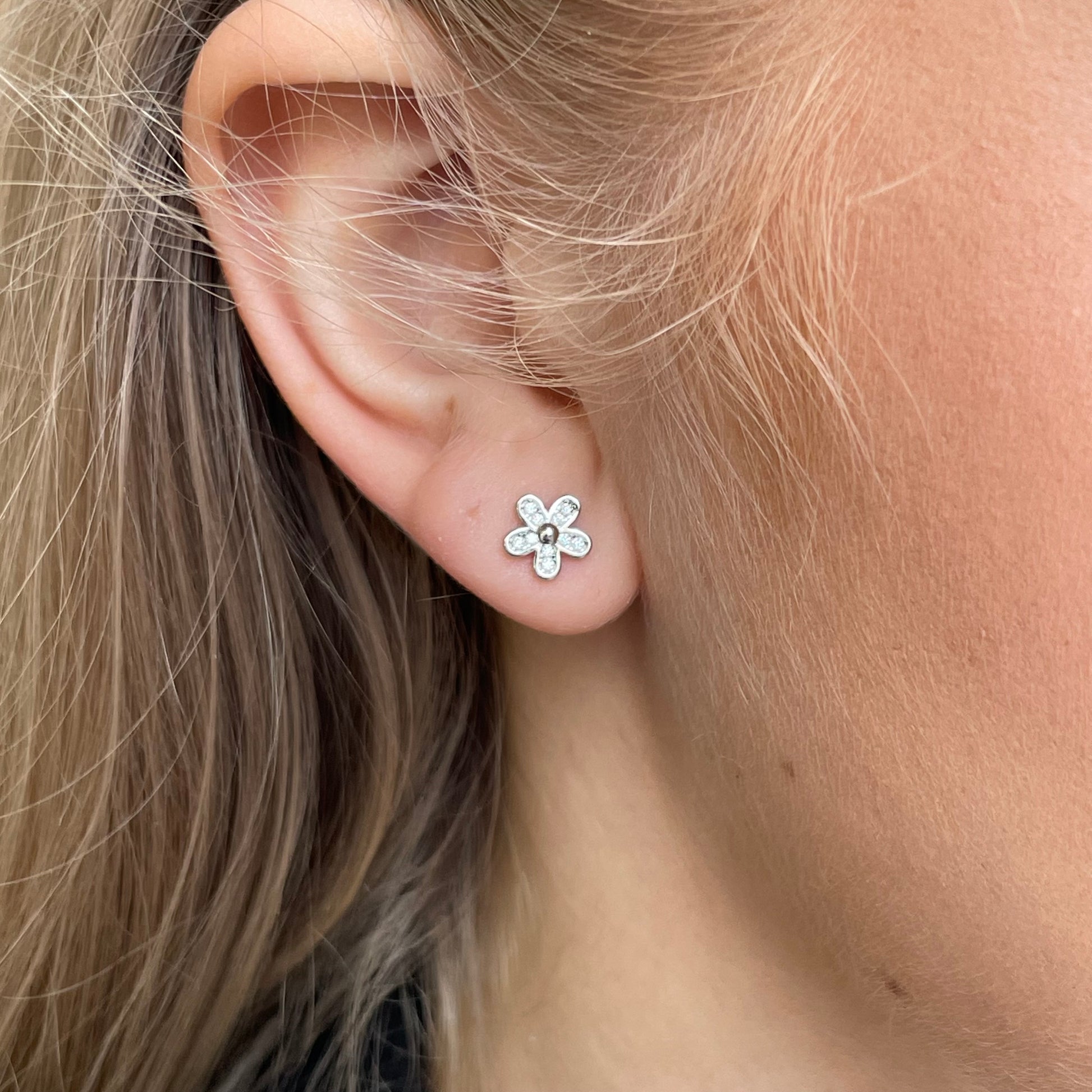 Silver CZ flower stud earrings by Insignia featuring sparkling cubic zirconia in a floral design.