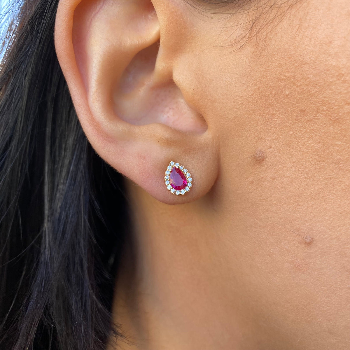 NJO 9ct gold created ruby and CZ halo pear-shaped stud earrings featuring sparkling stones and a polished gold finish.