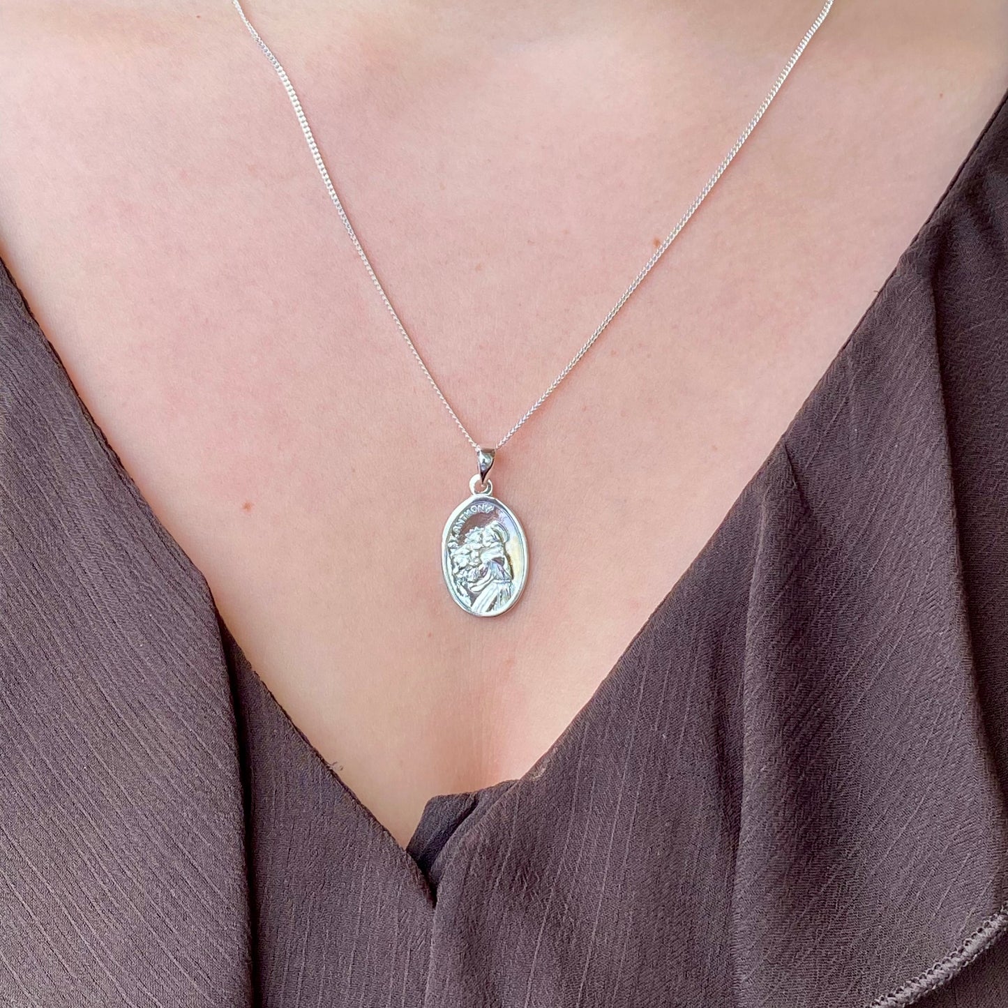 Silver St. Anthony medal necklace by Clandela featuring a detailed religious pendant on a chain.