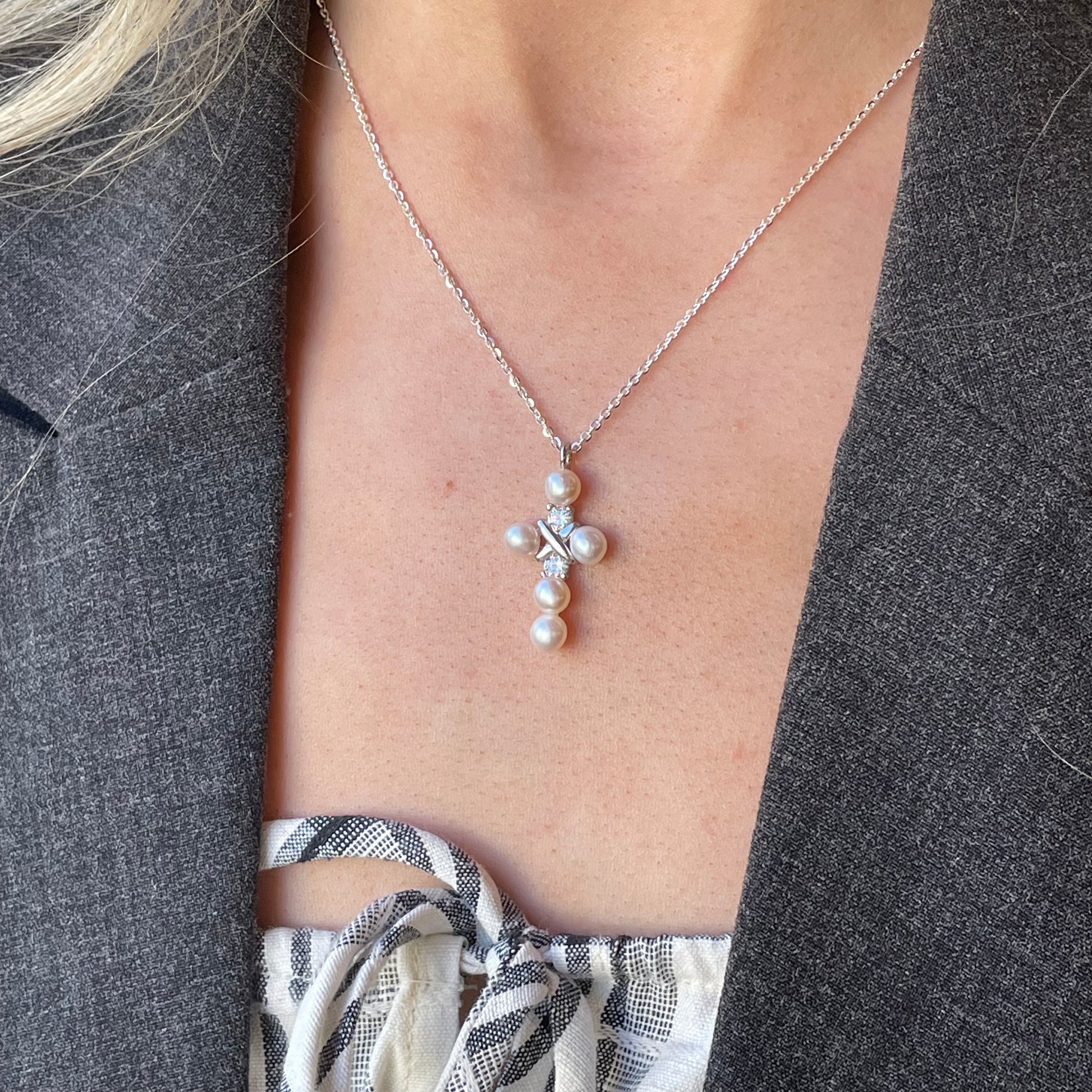 Silver CZ and 5mm freshwater pearl cross necklace on an 18-inch chain by Comero, featuring a detailed silver cross pendant.