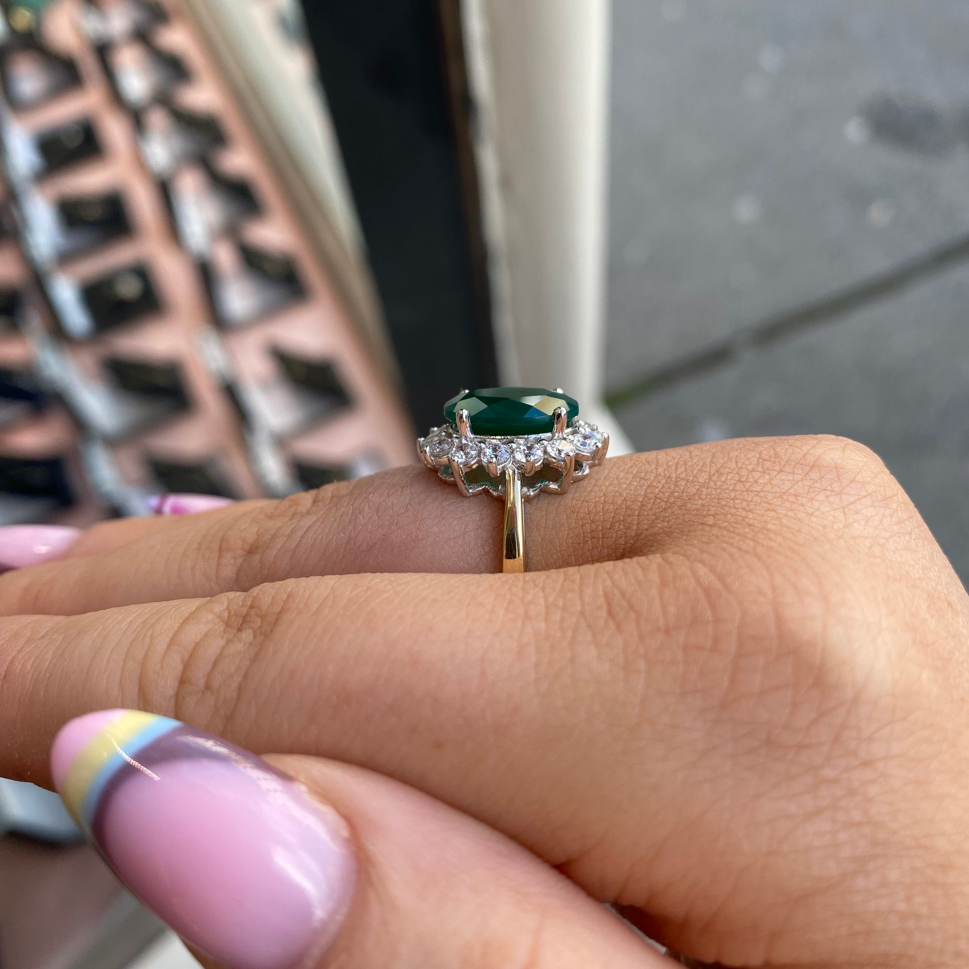 9ct gold created emerald and CZ oval cluster ring with intricate design, featuring sparkling stones and a polished band.