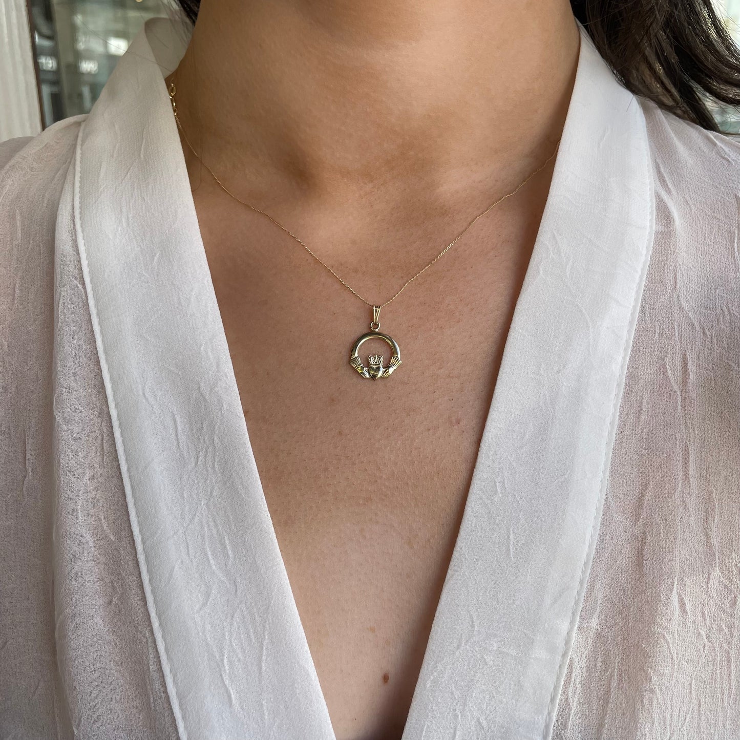 10ct gold Claddagh necklace by Facet featuring a large pendant with a detailed heart and crown design on a delicate chain.
