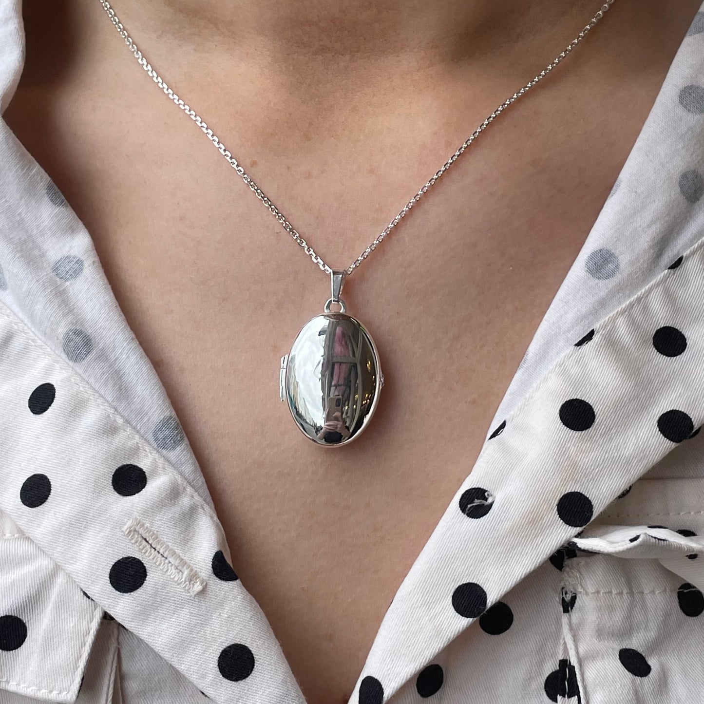 Silver Secret Heart Oval Locket Necklace by Clandela, featuring a delicate oval-shaped pendant with an intricate heart design.
