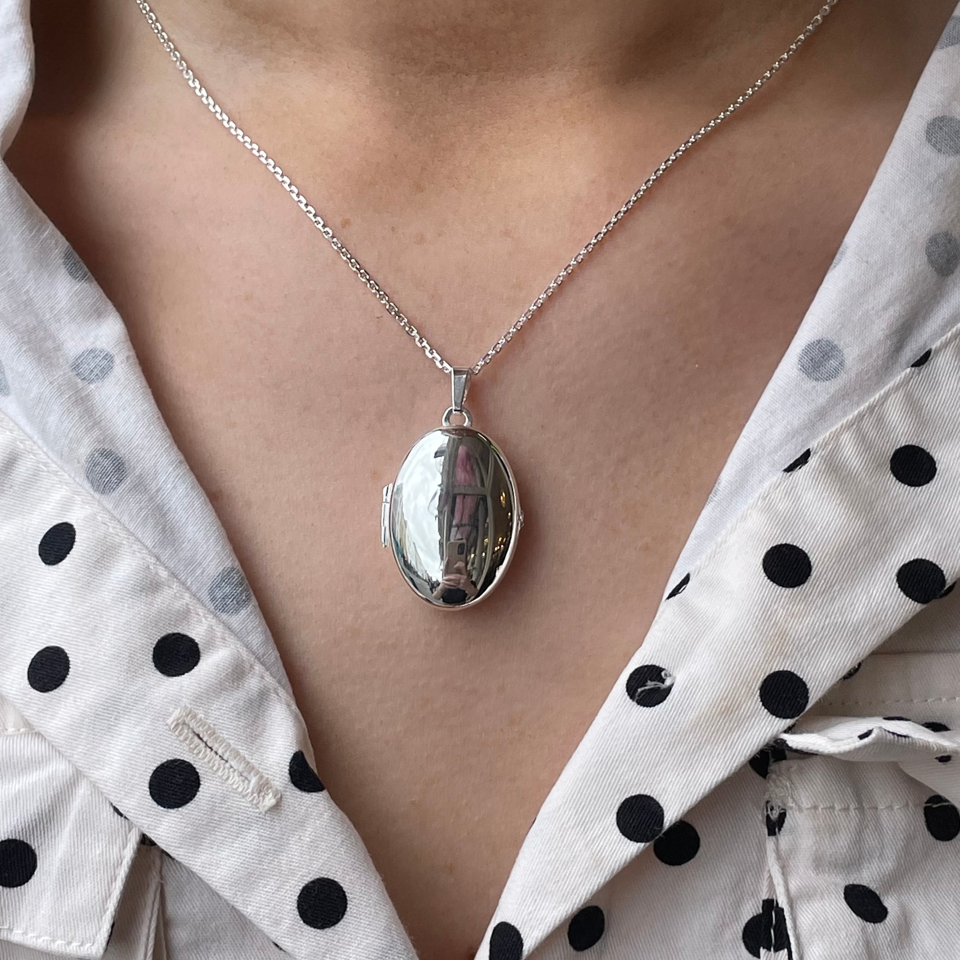 Silver Secret Heart Oval Locket Necklace by Clandela, featuring a delicate oval-shaped pendant with an intricate heart design.