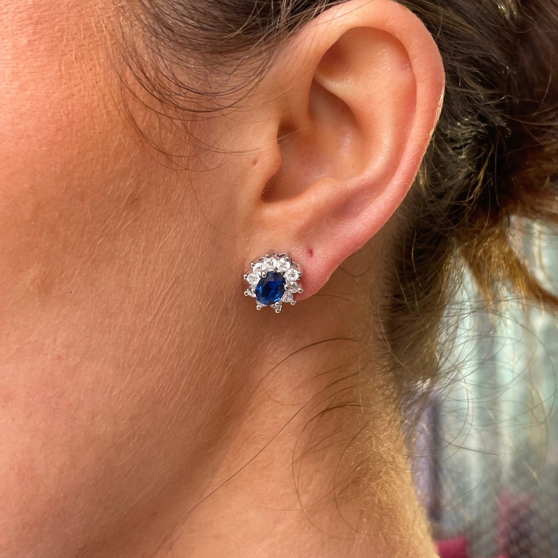 Silver oval CZ Diana stud earrings with sapphire blue accents by Comero, featuring sparkling cubic zirconia stones.