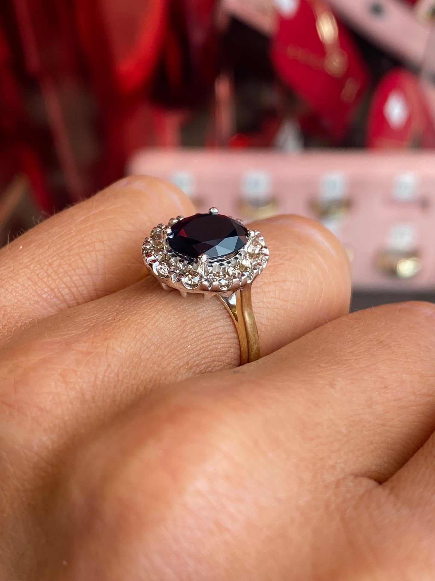 9ct gold sapphire and diamond ring by UJT featuring a central sapphire gemstone surrounded by sparkling diamonds.