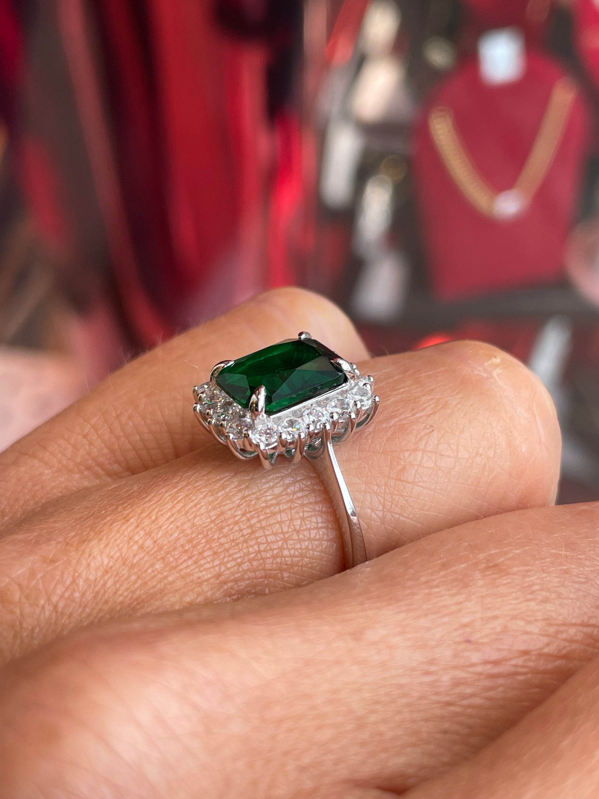 Silver emerald green CZ statement ring by Comero featuring a large green gemstone and intricate silver band design.