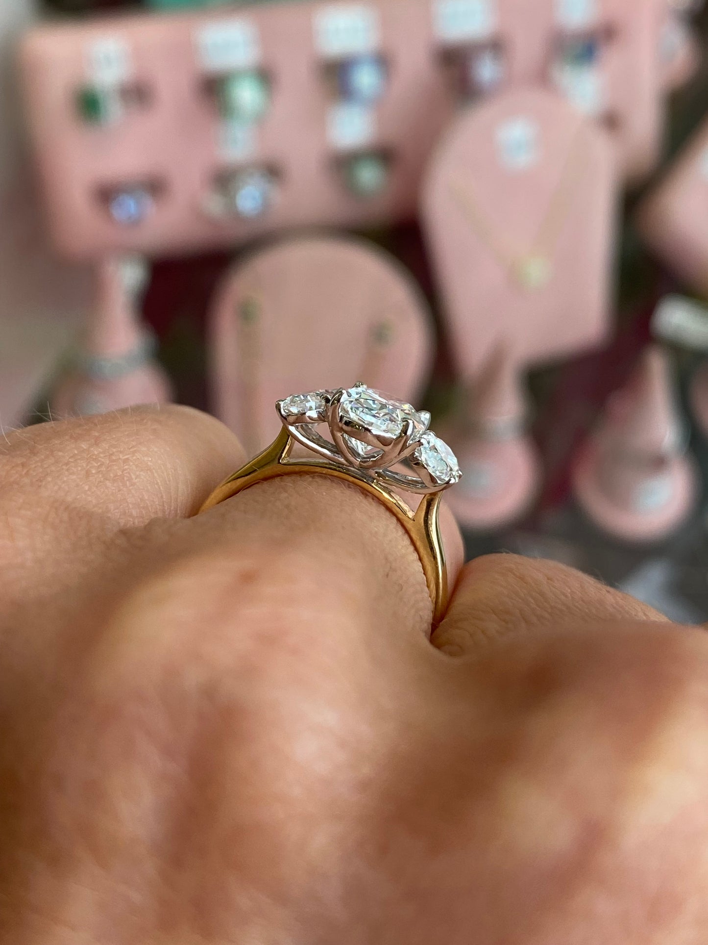 TCA 18ct gold oval trilogy engagement ring with lab-certified 2.40ct center stone and side diamonds on a polished band.