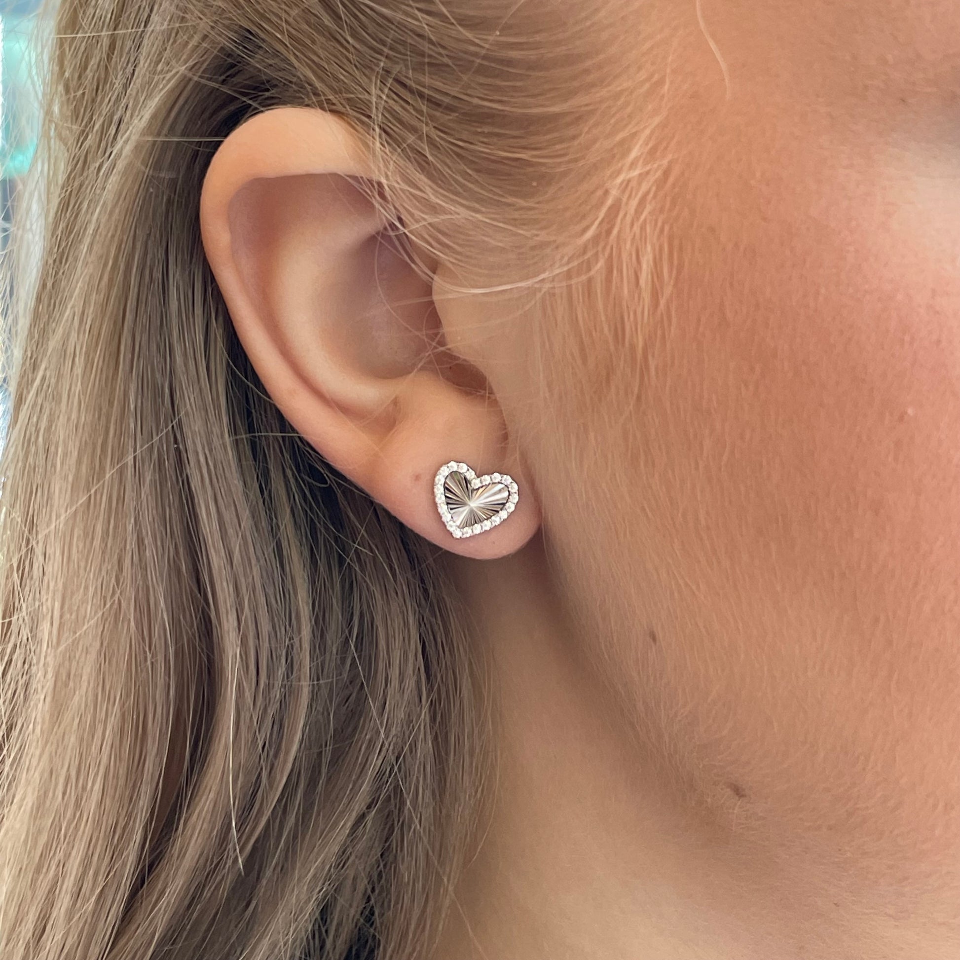 Silver CZ heart stud earrings by Comero featuring sparkling cubic zirconia stones and a classic, elegant design.