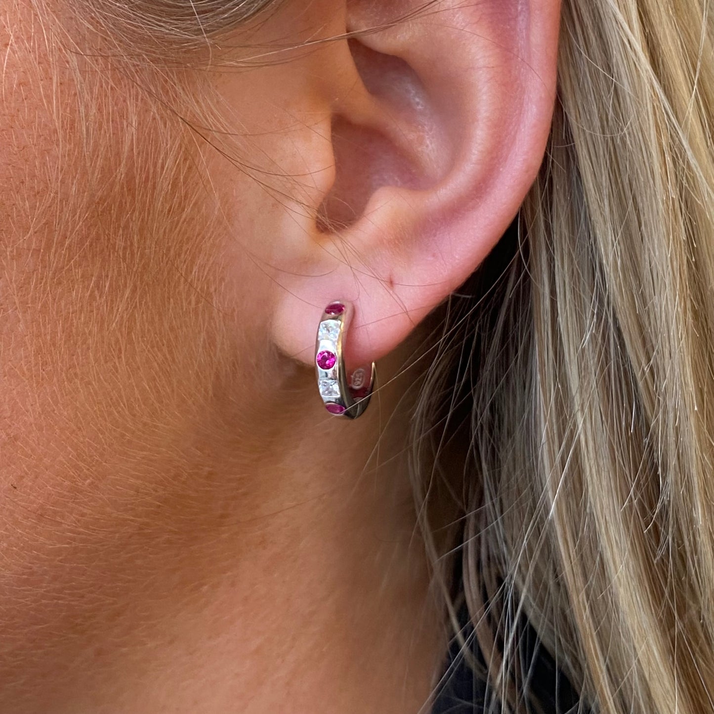 Silver hoop earrings with red cubic zirconia stones by Comero, featuring a stylish and sparkling jewelry design.