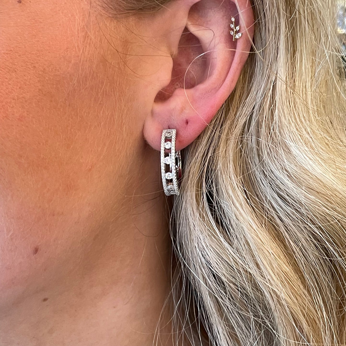 Silver two-row CZ hoop earrings by Comero featuring sparkling cubic zirconia stones and a stylish hoop design.