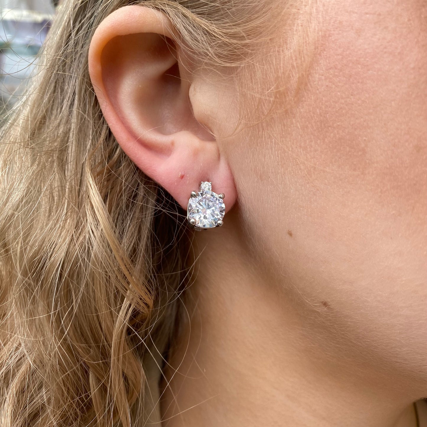 Silver CZ clip-on earrings by Comero featuring sparkling cubic zirconia stones and sleek metallic finish.