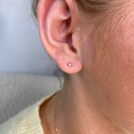 Silver nano CZ stud earrings for kids by Comero, featuring sparkling cubic zirconia stones on small silver posts.