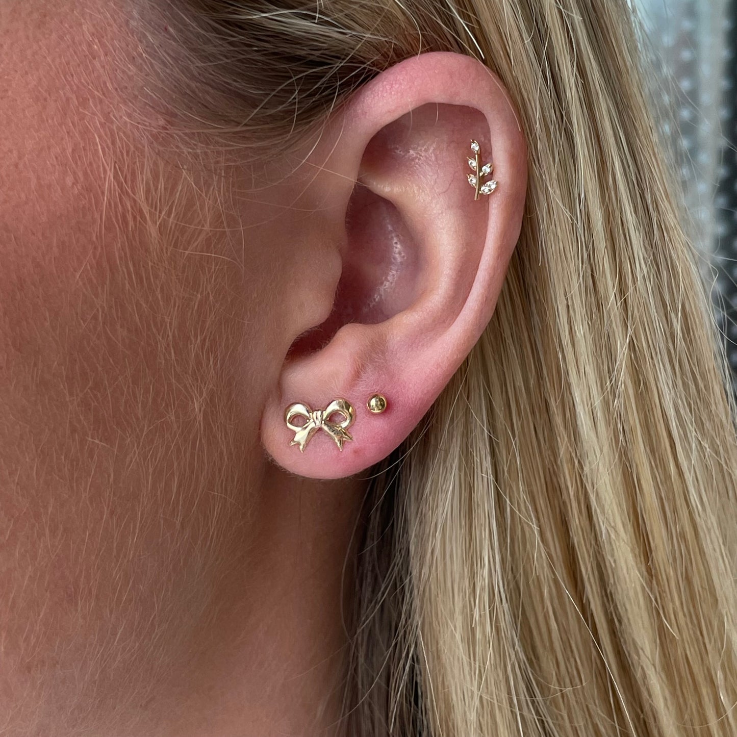 9ct gold pretty bow stud earrings by THC, featuring delicate bow design with polished finish on classic earring posts.