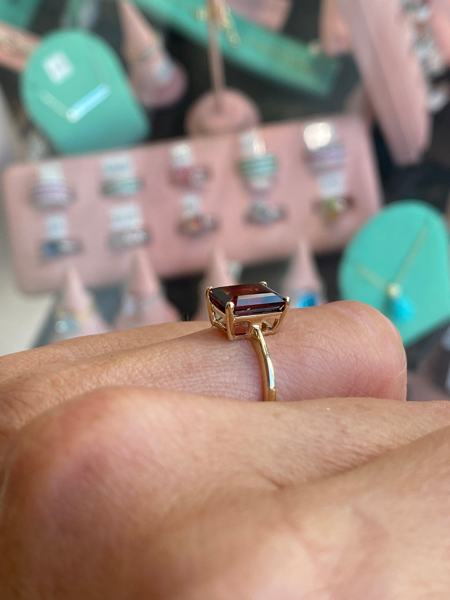 Insignia 9ct gold emerald cut garnet ring showcasing a rectangular deep red gemstone set in a gold band.