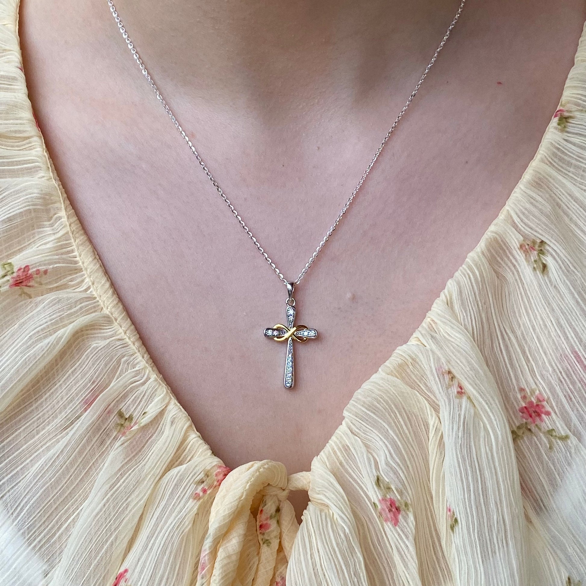 Silver CZ infinity cross necklace with two-tone finish, featuring a sleek design and THC branding.