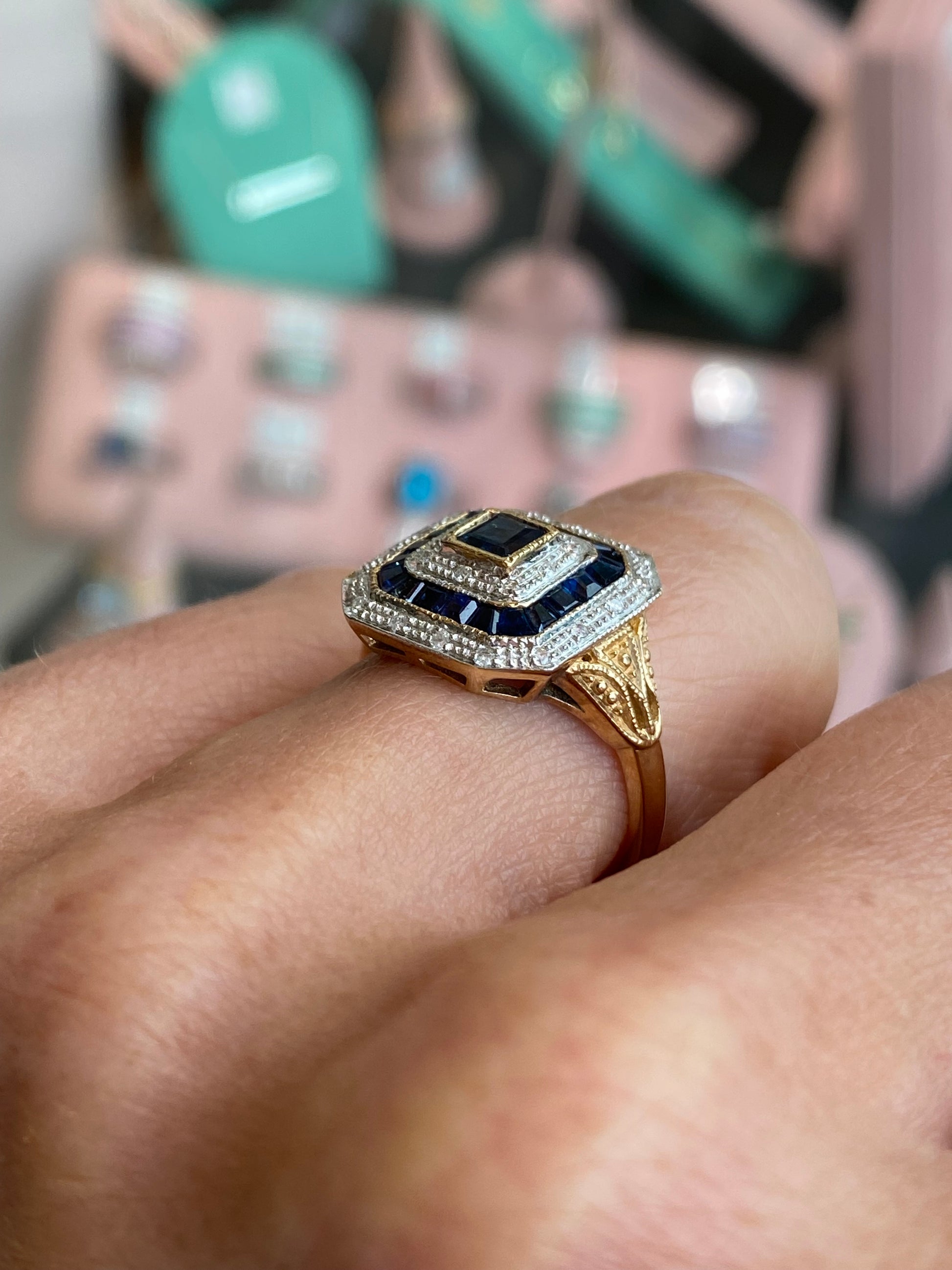 9ct gold sapphire and diamond ring by Luke Stockley, featuring a central sapphire gemstone surrounded by sparkling diamonds.