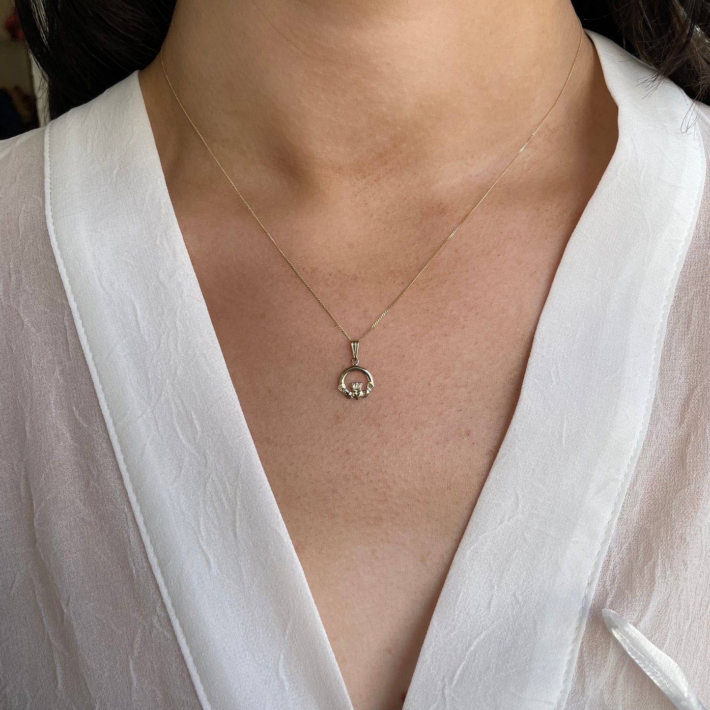 Mini 10ct Gold Claddagh Necklace from Facet featuring a detailed Claddagh charm on a delicate gold chain.