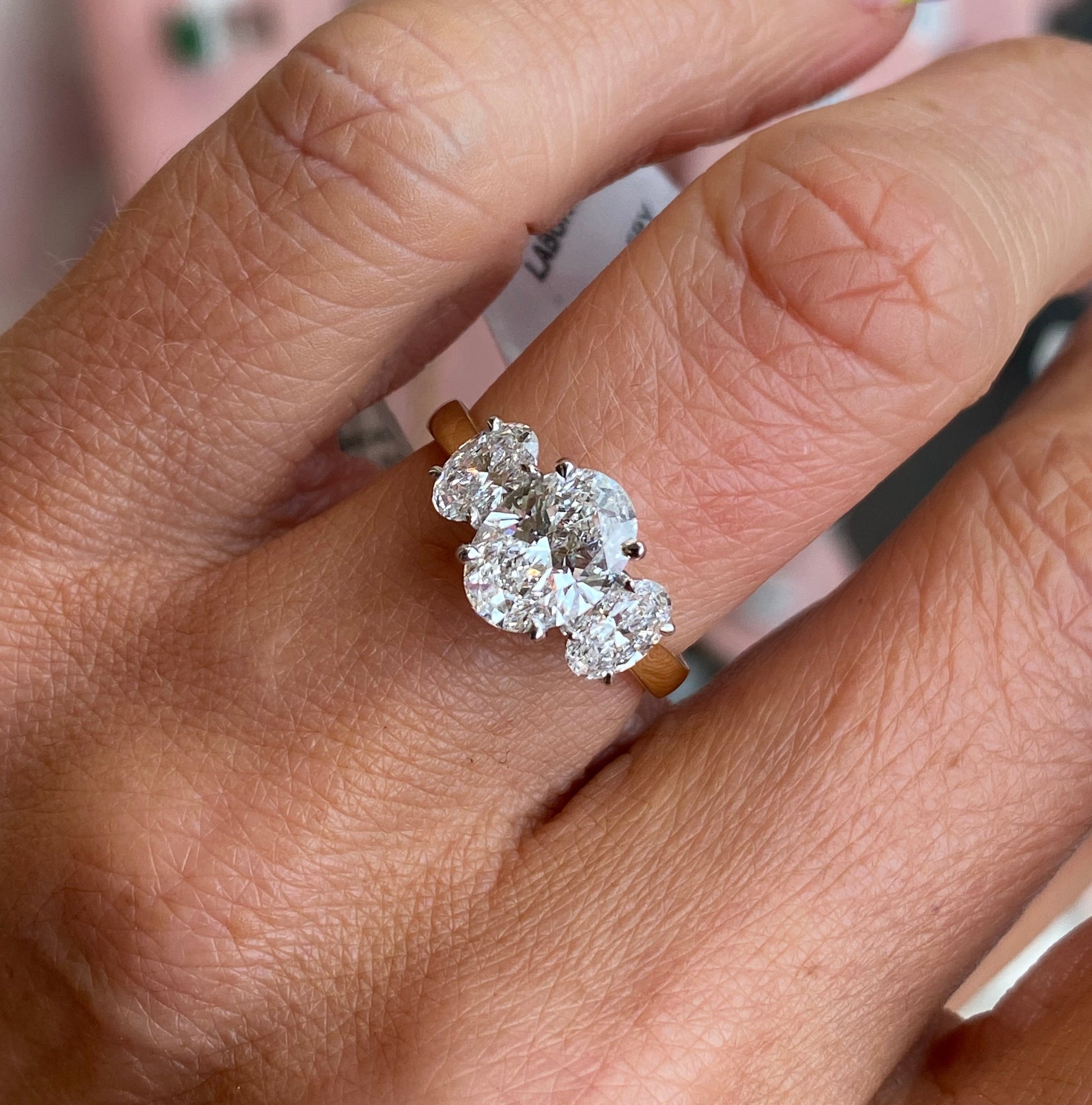 18ct gold oval trilogy engagement ring by TCA with lab-certified 2.40ct center stone and side diamonds, classic and elegant design