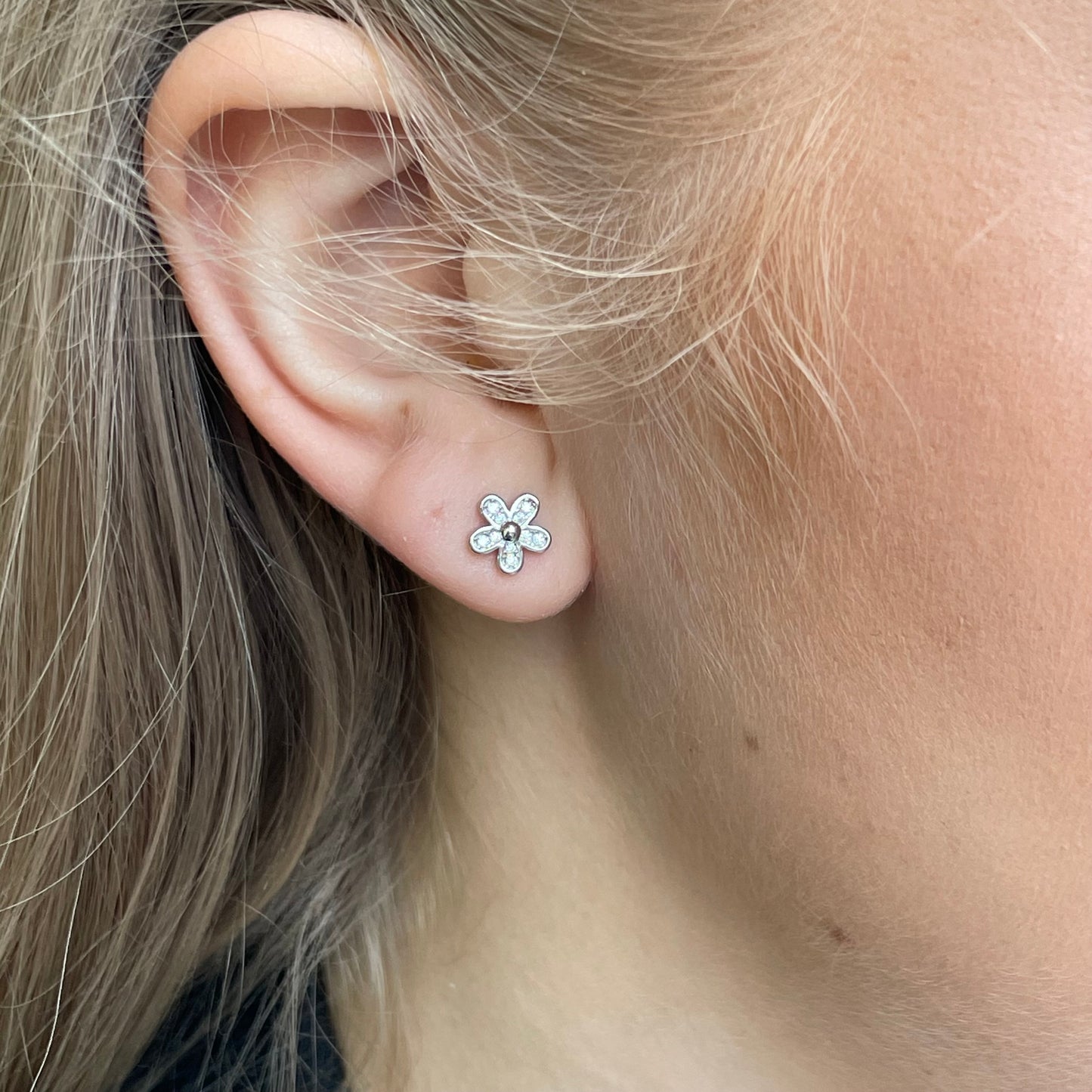 Silver CZ flower stud earrings by Insignia featuring sparkling cubic zirconia in a floral design.