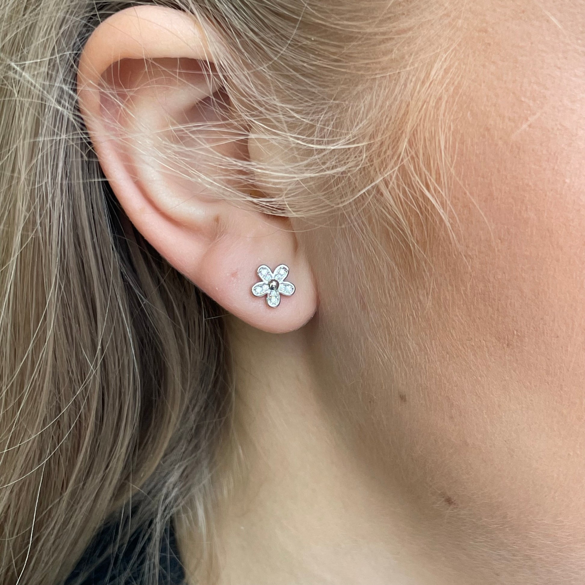 Silver CZ flower stud earrings by Insignia featuring sparkling cubic zirconia in a floral design.