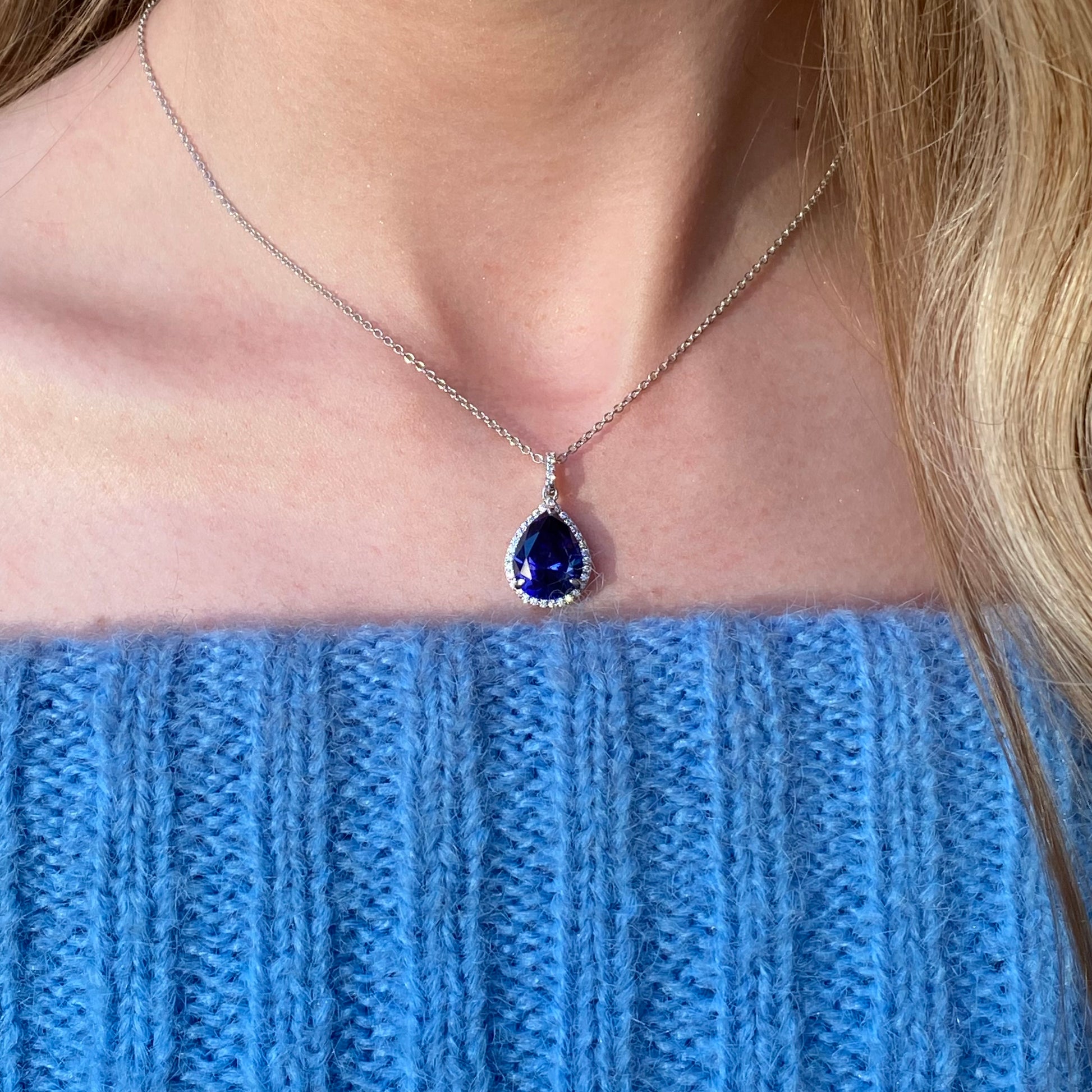 Silver CZ pear halo necklace with tanzanite gemstone, featuring a sparkling pendant on a delicate chain.
