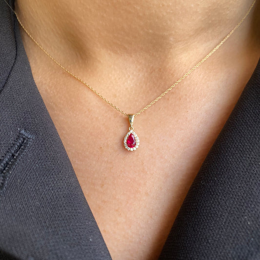 NJO 9ct gold created ruby and CZ halo pear-shaped pendant necklace with intricate design and sparkling stones.