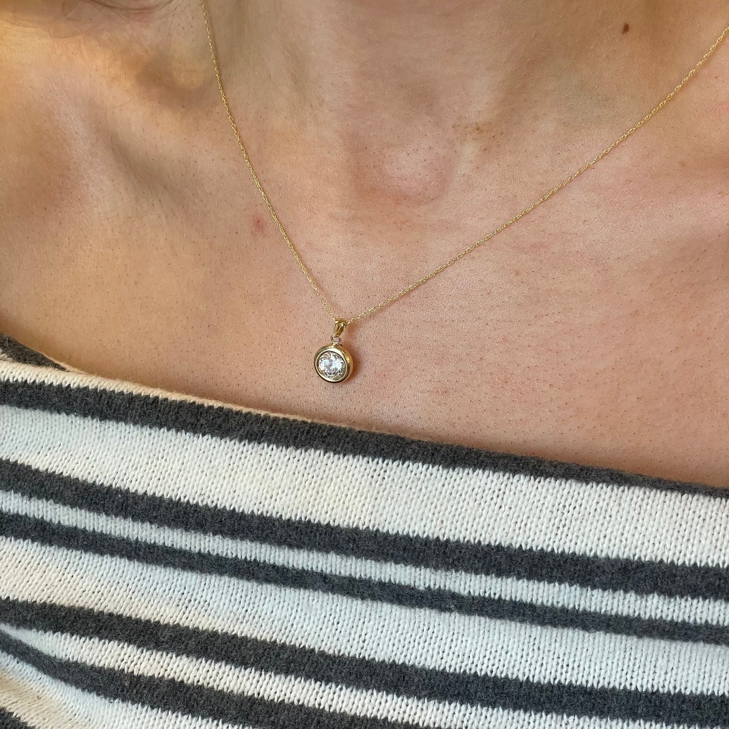 9ct gold bezel set CZ necklace with a 6mm round cubic zirconia pendant, featuring a delicate chain and elegant design.