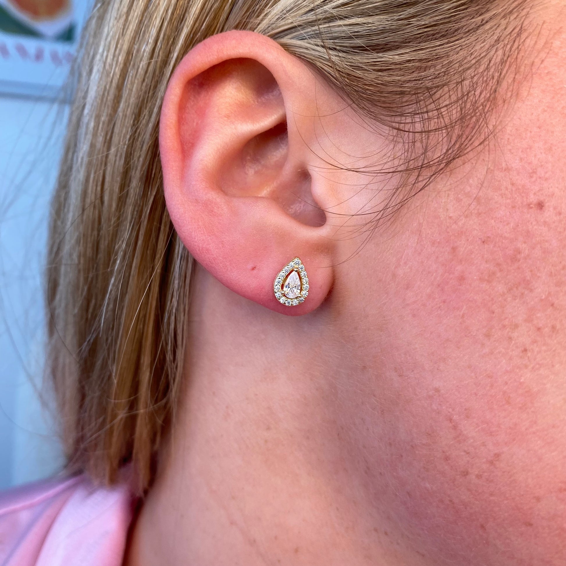 Insignia Sunshine CZ Pear Halo Stud Earrings featuring sparkling pear-shaped and round cubic zirconia stones on silver settings.