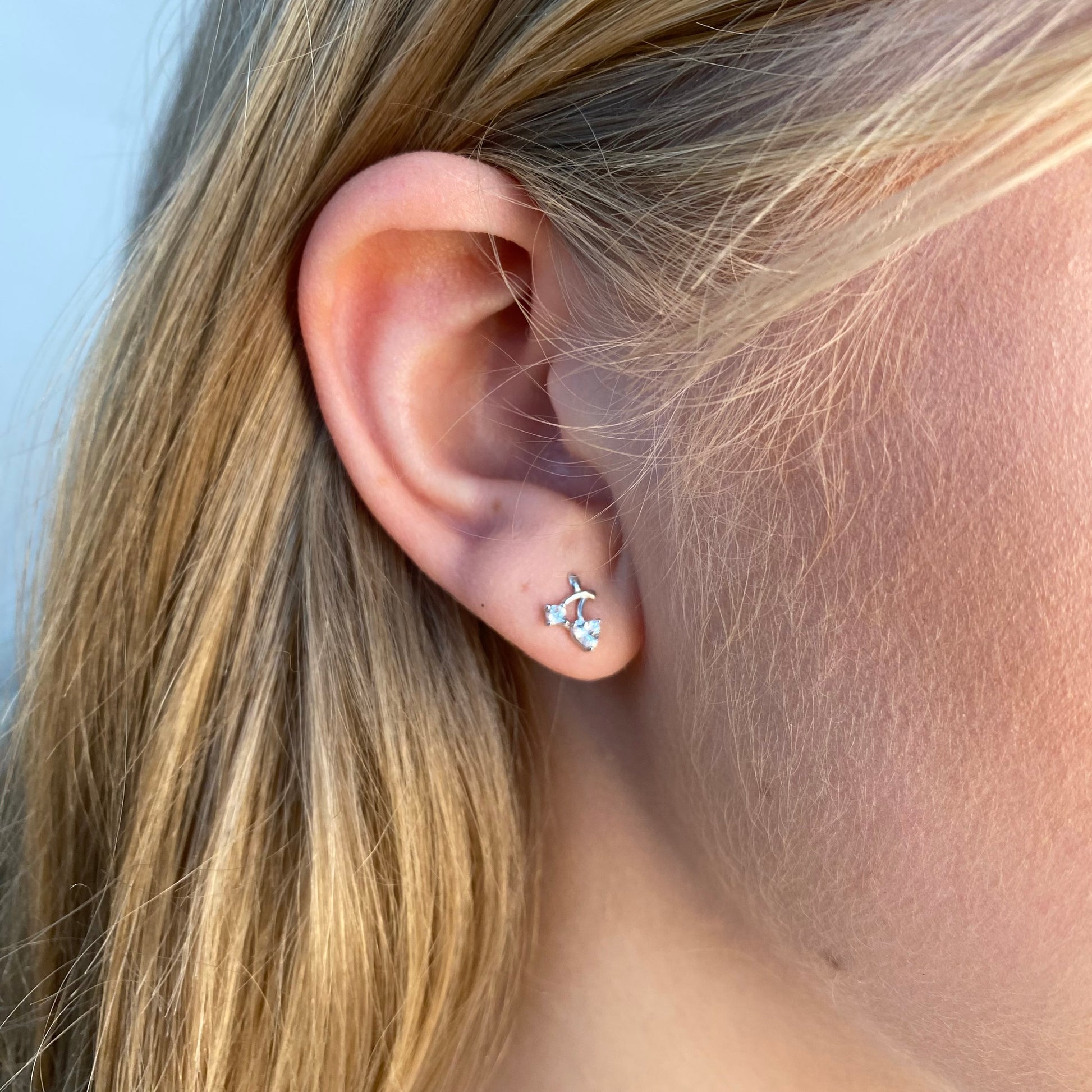 Silver Cherry CZ Kid's Earrings by Comero featuring sparkling cherry-shaped studs with cubic zirconia accents.