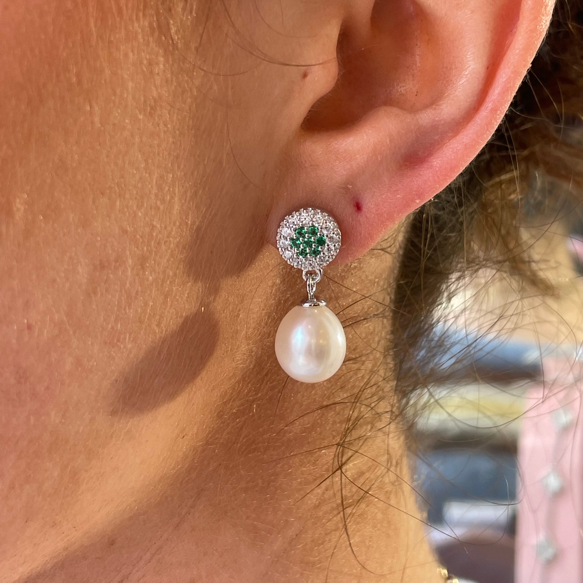 Silver emerald green CZ and freshwater pearl drop earrings by Comero, featuring sparkling stones and elegant pearl accents.